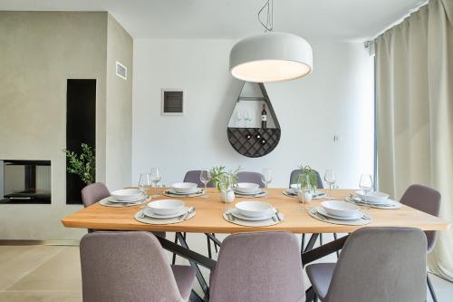 a dining room with a wooden table and chairs at Villa Sponza in Medulin
