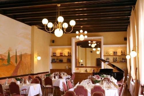 una sala da pranzo con tavoli, sedie e lampadario a braccio di In Piazza a Bad Klosterlausnitz