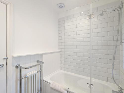 a bathroom with a tub and a glass shower at Grace Cottage - Emsworth in Emsworth
