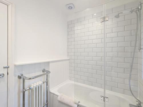 a bathroom with a tub and a glass shower at Grace Cottage - Emsworth in Emsworth