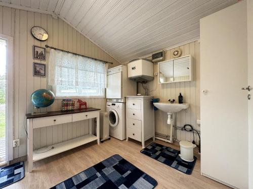 a small kitchen with a sink and a washing machine at Mysig stuga med villastandard i Tanumshede in Tanumshede