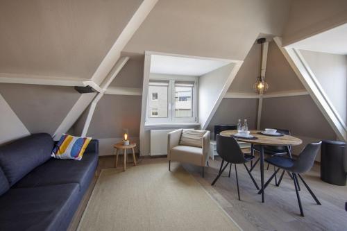 uma sala de estar com um sofá azul e uma mesa em Zeehuis Zandvoort em Zandvoort
