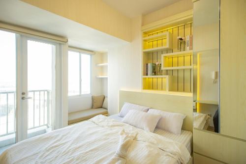 a bedroom with a white bed and a window at Tokyo Riverside Apartment @ PIK 2 in Tangerang