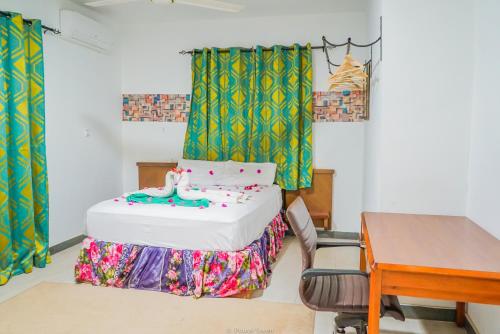 a bedroom with a bed and a desk and a table at MGM Apartments Gambia in Kololi
