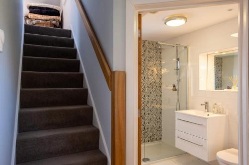 a bathroom with a staircase next to a shower at Harbour View in Lymington