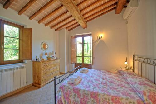 - une chambre avec un grand lit dans une pièce dotée de fenêtres dans l'établissement Casa Maria Luisa by PosarelliVillas, à San Gusmè