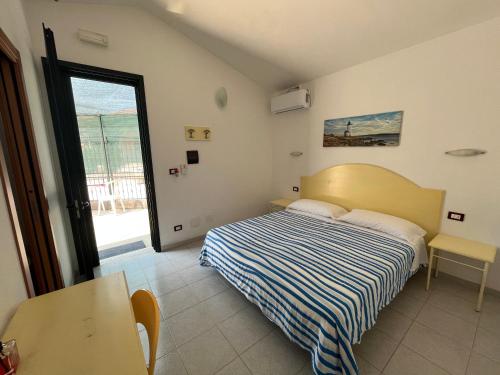 1 dormitorio con cama, mesa y ventana en Camera felice, en Campomarino