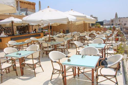 a row of tables and chairs with umbrellas on a patio at Pyramids Valley Boutique Hotel in Cairo