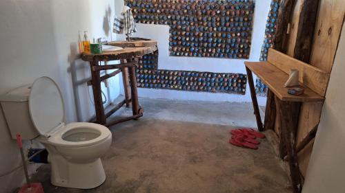 a bathroom with a toilet and a wooden table at Chemka Paradise Eco Lodge in Boma la Ngombe