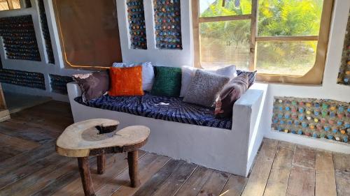 a couch with colorful pillows on it in a room at Chemka Paradise Eco Lodge in Boma la Ngombe