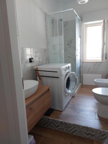 a bathroom with a washing machine and a sink at Sicily Holidays Home in Calatabiano