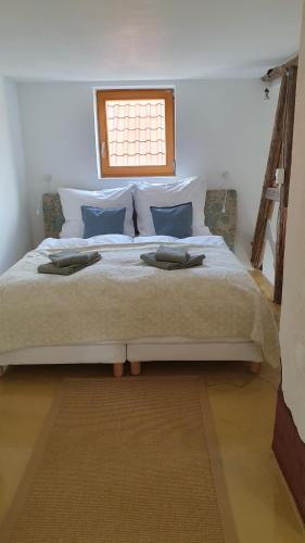 a bedroom with a large bed with blue pillows and a window at Gartenhaus Schlanstedt in Schlanstedt