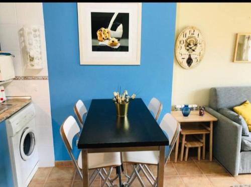 un comedor con una mesa negra y una pared azul en Apartamento con encanto, en Jaca