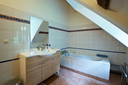 une salle de bain avec un lavabo et une baignoire dans l'établissement clos du Mont maison sur falaise, à Étretat