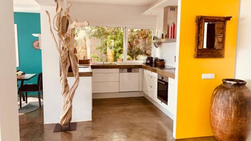 eine Küche mit gelben Wänden und einer Vase in der Mitte in der Unterkunft Villa El Casot in Begur