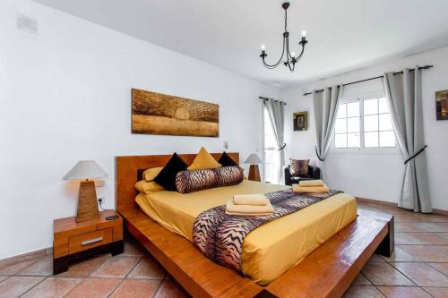 een slaapkamer met een groot bed met een houten frame bij Villa Guapa in San Miguel de Abona