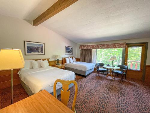Habitación de hotel con 2 camas y mesa en Otsego Resort en Gaylord