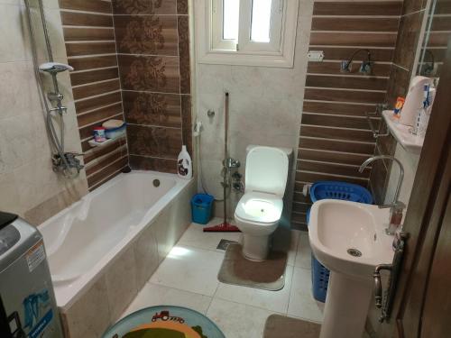 a bathroom with a toilet and a tub and a sink at شقه فاخره للايجار المفروش الابراهيميه على البحر in Alexandria