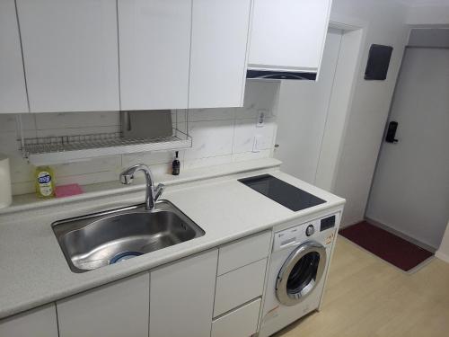 a kitchen with a sink and a washing machine at Newly Renovated 2 Bedroom Apartment in Seoul