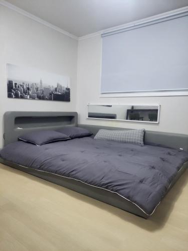 a large bed in a white room with avertisementatronatronstrationstration at Newly Renovated 2 Bedroom Apartment in Seoul