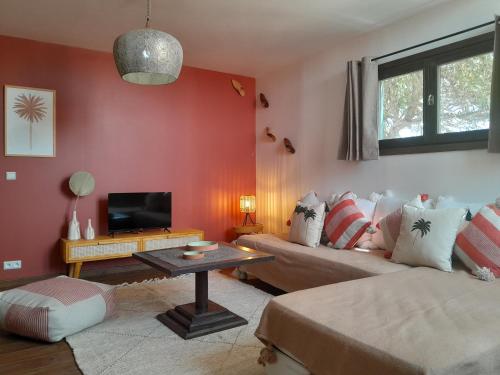 a living room with a couch and a tv at Vent Des Dunes in Essaouira