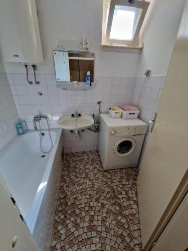 a small bathroom with a sink and a washing machine at Bugojno Stan in Bugojno