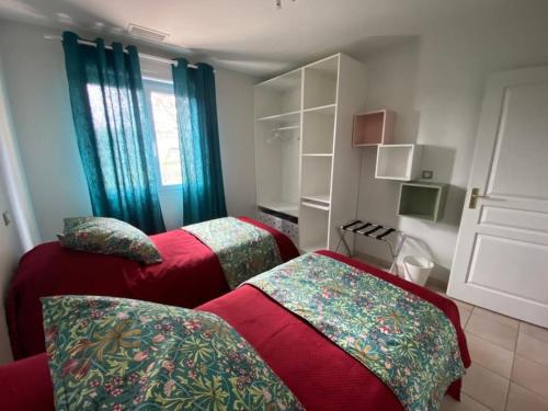 two beds in a room with blue curtains at Gite de Gabi Jacuzzi in Pompignan