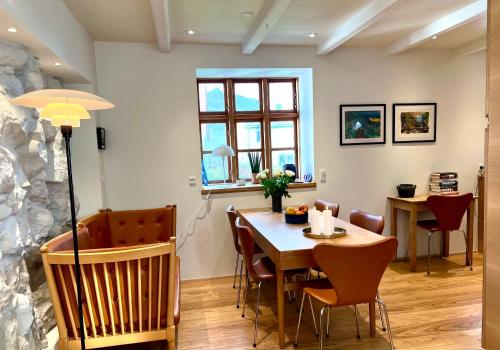 uma sala de jantar com mesa e cadeiras em Cozy traditional home, Syðrugøta em Syðrugøta