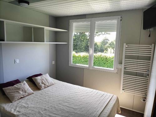 une chambre avec un lit et deux fenêtres dans l'établissement gite piscine campagne, à Saint-Sauveur-des-Landes