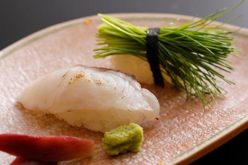 a plate of food with a piece of sushi and a plant at Kaikatei Hanagozen in Kyotango