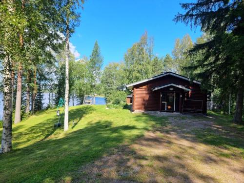 une cabane en rondins dans les bois avec une pelouse dans l'établissement Holiday Home Saarenpää by Interhome, à Koivisto
