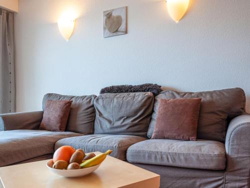 ein Wohnzimmer mit einem Sofa und einer Obstschale auf einem Tisch in der Unterkunft Apartment Christiania 2 L3 by Interhome in Nendaz
