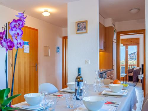 uma mesa de jantar com uma garrafa de vinho em Apartment Les Chouettes 11 by Interhome em Nendaz