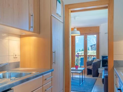 uma cozinha com um lavatório e uma sala de estar em Apartment Les Chouettes 11 by Interhome em Nendaz