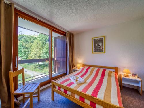 une chambre avec un lit et une grande fenêtre dans l'établissement Apartment Pegase Phenix-39 by Interhome, au Corbier