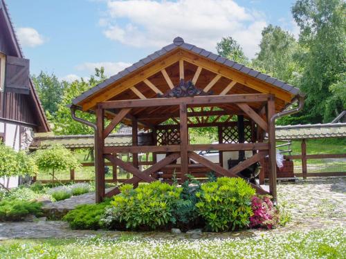 a wooden gazebo in a garden with flowers at Holiday Home Sianowska Huta by Interhome in Prokowo
