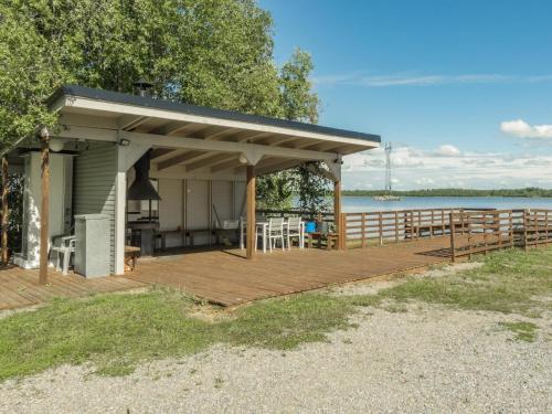 a building with a deck next to a lake at Holiday Home Aamunkoi by Interhome in Pyhäsalmi