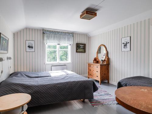 1 Schlafzimmer mit 2 Betten, einem Tisch und einem Spiegel in der Unterkunft Chalet Mjöshult - SND157 by Interhome in Hjorted