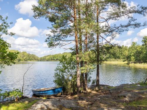 a blue boat on the shore of a lake at Chalet Mjöshult by Interhome in Hjorted