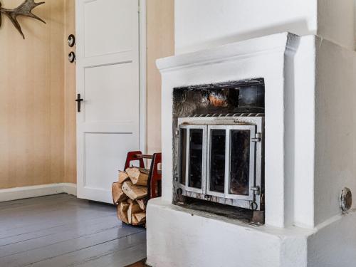 a white fireplace in a living room at Chalet Mjöshult by Interhome in Hjorted