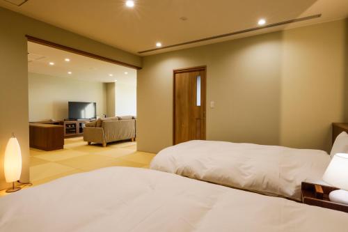 a bedroom with two beds and a living room at Kaikatei Hanagozen in Kyotango