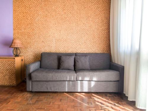 a couch sitting in a living room next to a wall at Apartment Comfort by Interhome in Riva del Garda