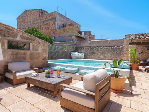 un patio trasero con una piscina con sillas y una mesa en Holiday Home Cas padri by Interhome, en Vilafranca de Bonany