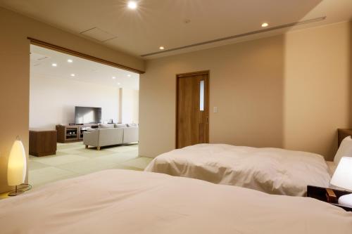 a bedroom with two beds and a living room at Kaikatei Hanagozen in Kyotango
