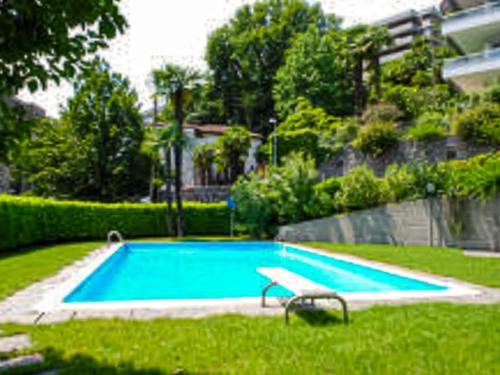 uma piscina com um banco na relva em Apartment Il Parco by Interhome em Lugano