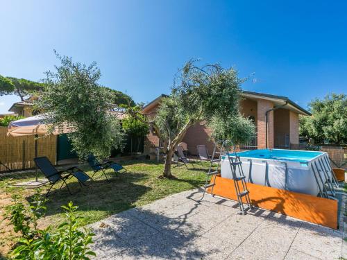 un cortile con piscina, sedie e una casa di Holiday Home Dream House by Interhome a Follonica