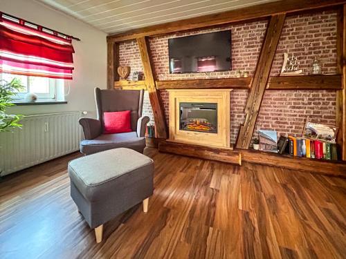 a living room with a fireplace and a chair and a tv at Apartment Marie by Interhome in Großschönau