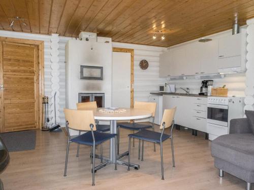 uma cozinha e sala de jantar com mesa e cadeiras em Holiday Home Aamunkoin rantatupa by Interhome em Pyhäsalmi