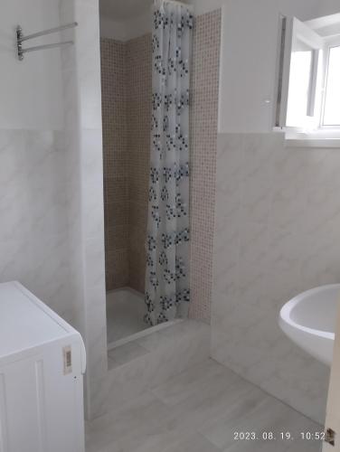 a white bathroom with a shower and a sink at Helena Vendégház in Siófok
