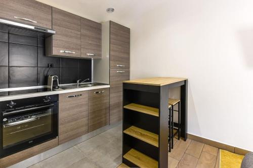 eine Küche mit Holzschränken und einer Spüle in der Unterkunft Appartement moderne en plein coeur de Béziers in Béziers